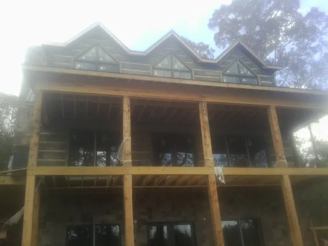 Dormers and porch framing on a large log home under construction — Roof Coating work by our crew in Valrico