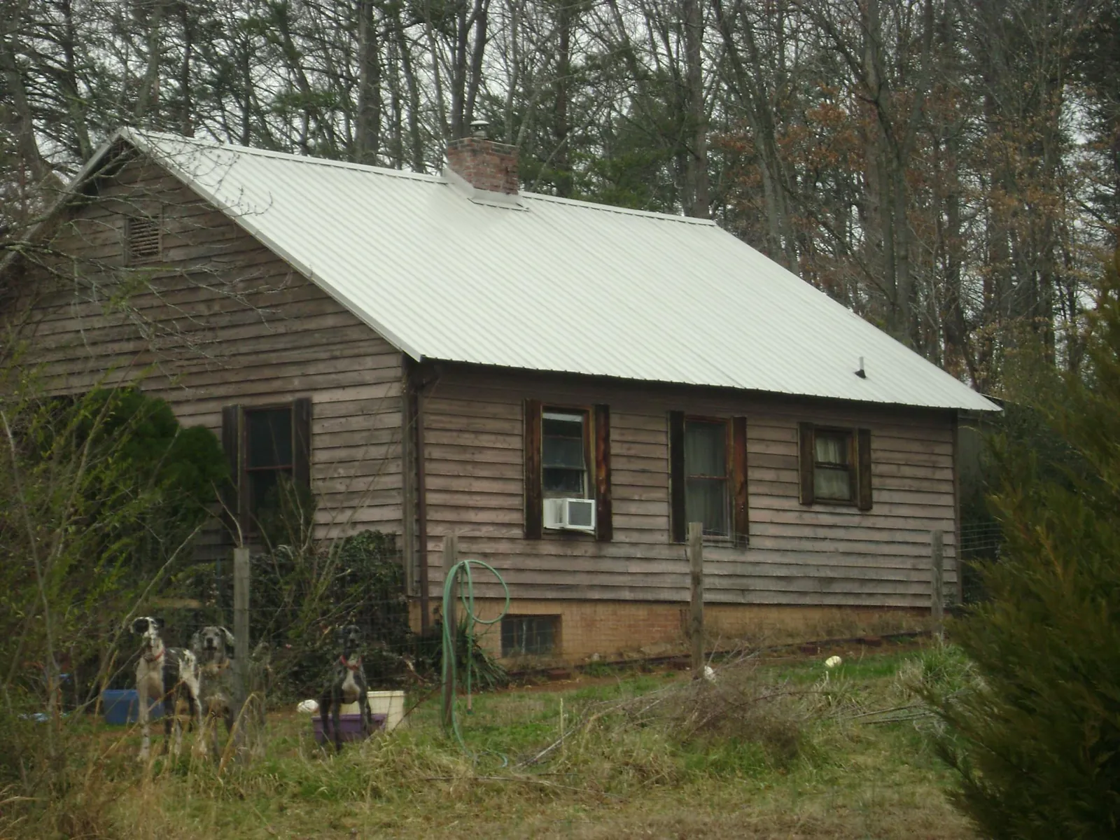 White metal roof on an old wood sided farmhouse, from a Metal Roof Installation job in Valrico